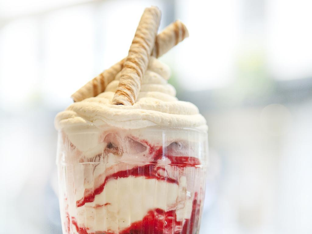 伦敦 巴比肯客房酒店 外观 照片 The photo shows a delicious dessert in a clear glass dish. It features layers of creamy ice cream or whipped cream, swirled with a vibrant red fruit sauce. Topping the dessert are two rolled wafer sticks, adding a decorative touch. The overall presen