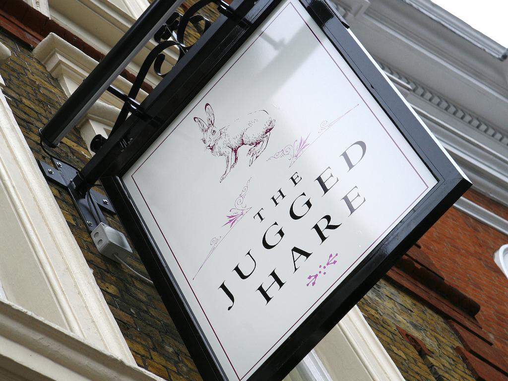 伦敦 巴比肯客房酒店 外观 照片 The photo shows a hanging sign for a place called "The Jugged Hare." The design features an illustration of a hare, along with the name displayed prominently in bold letters. The overall aesthetic combines an elegant font with delicate floral accents